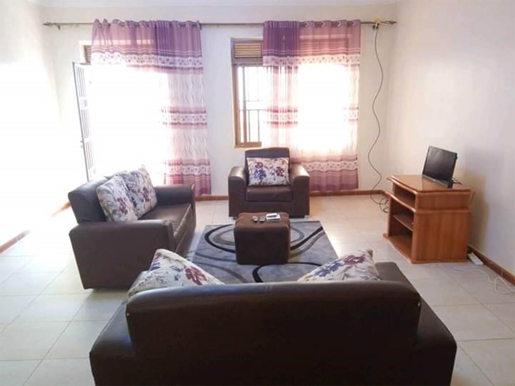A living room with two sofas, a coffee table, and a TV stand.