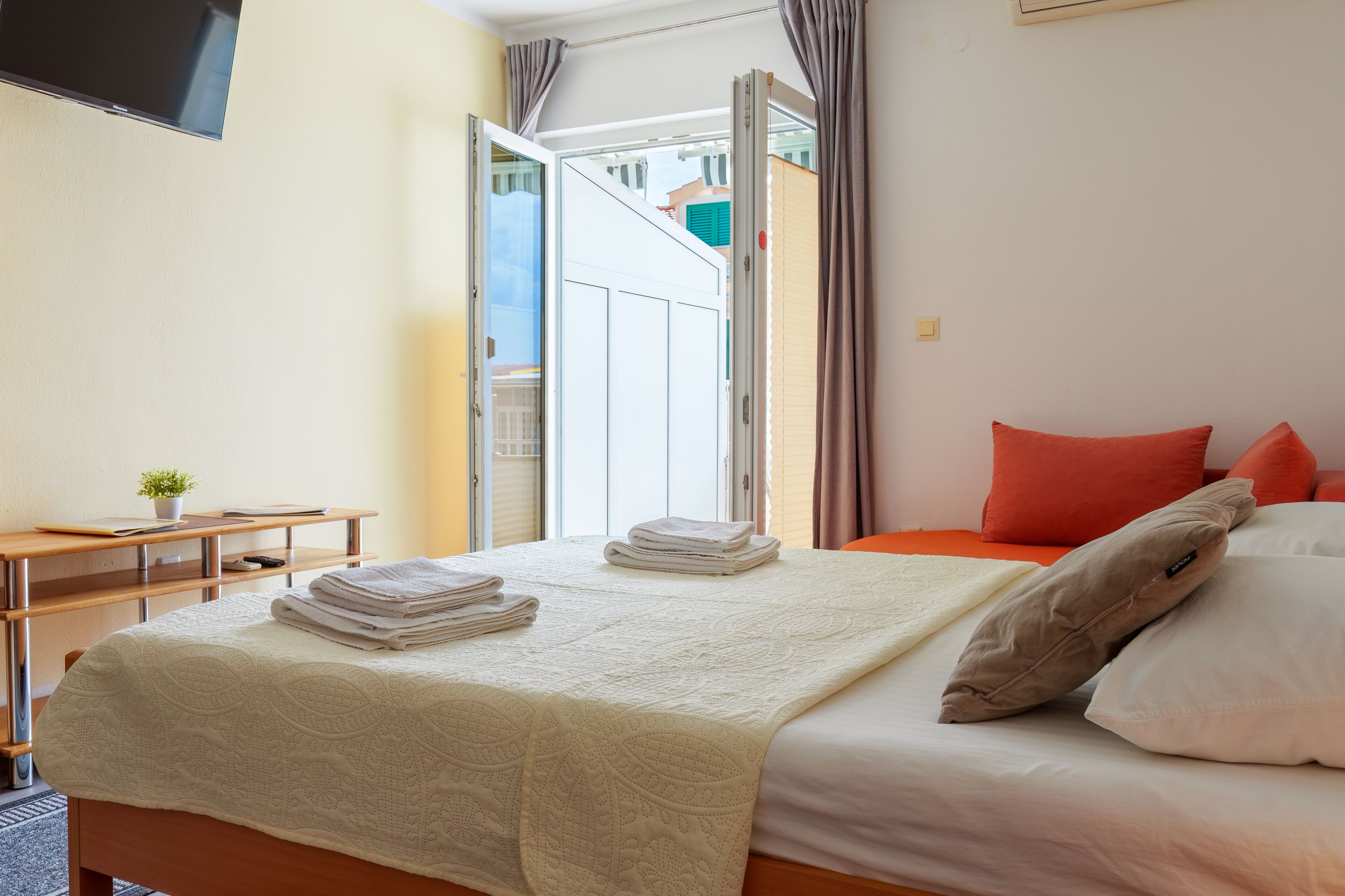 Ein Hotelzimmer mit Bett, Schreibtisch und Fernseher.