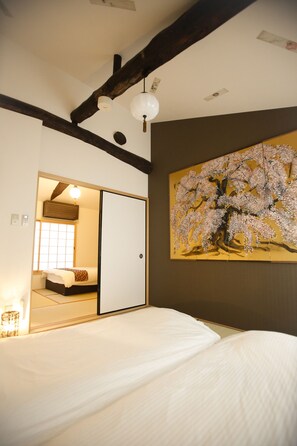 A bedroom with a bed, a sliding door, a painting of cherry blossoms, and a ceiling light. - Yamagata Kyomachi Hatago Daitokuji (Kyoto)