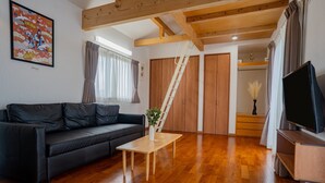 Un salon avec un canapé en cuir noir, une table basse en bois et un meuble pour la télévision.