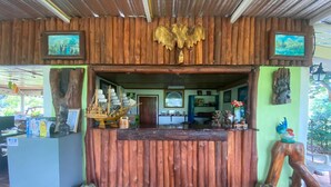 A wooden reception desk with a ship model, framed pictures, and a wooden sculpture.
