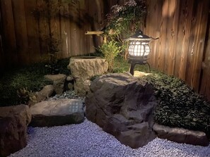 A garden with a stone pathway, a lantern, and a wooden fence. - Yamagata Kyomachi Hatago Kyoto Station (Kyoto)