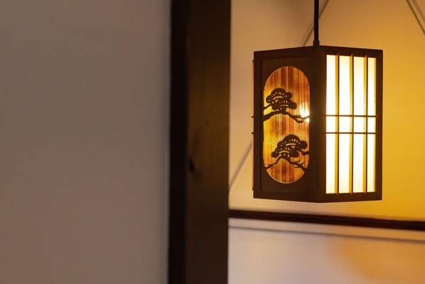 A traditional lantern with a wooden frame and a grid of vertical slats on the right side.