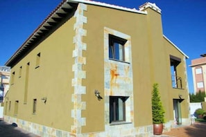 Stunning building with a unique stone accent and red-tiled roof.