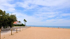 A wide sandy beach with a clear sky and a few palm trees. - 0646 Villa Amanda Beach (Denia)