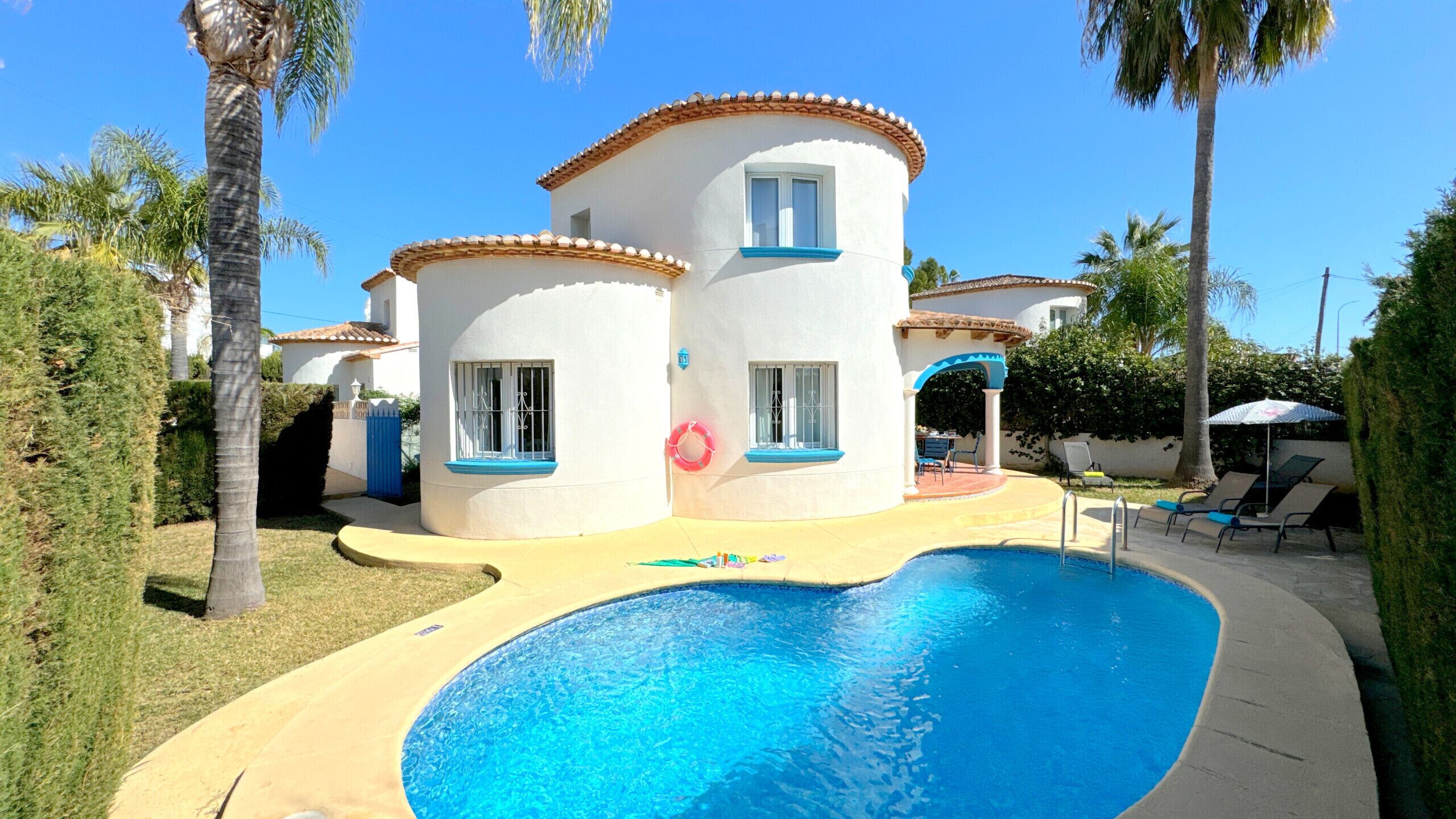 Une maison à deux étages avec une piscine dans le jardin.