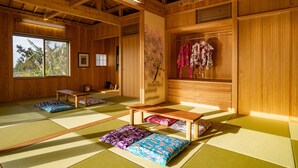 A traditional Japanese room with tatami flooring, wooden furniture, and a view of trees outside. - Yamagata Ryukyu Hatago Onna Bokairo (Onna)