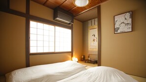 A traditional Japanese-style room with tatami flooring, a shoji screen window, and a futon bed. - Yamagata Kyomachi Hatago Kitayamaomiya (Kyoto)