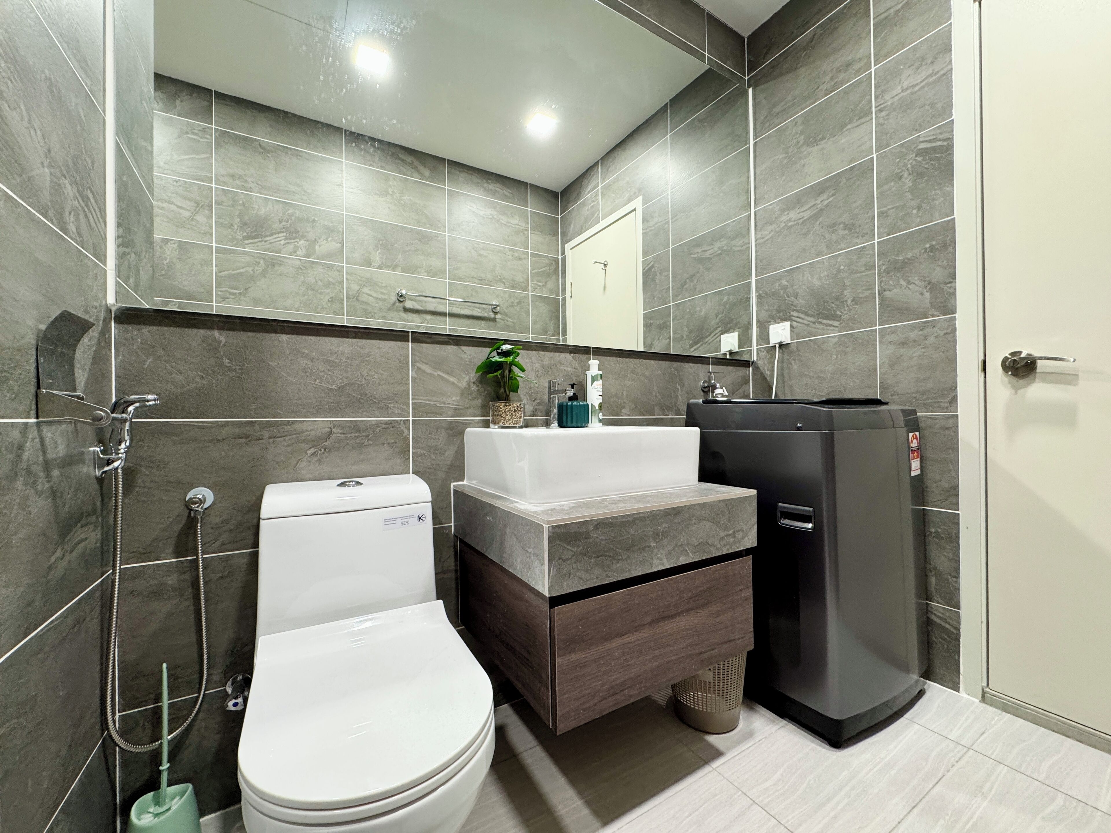 A modern bathroom with a toilet, sink, and shower.