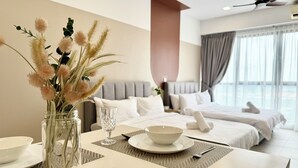 Une chambre d’hôtel avec un lit, une table à manger ornée d’un vase de fleurs, un bol et un verre.