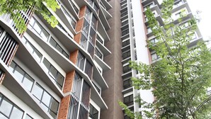 A high-rise building with multiple balconies and large windows.