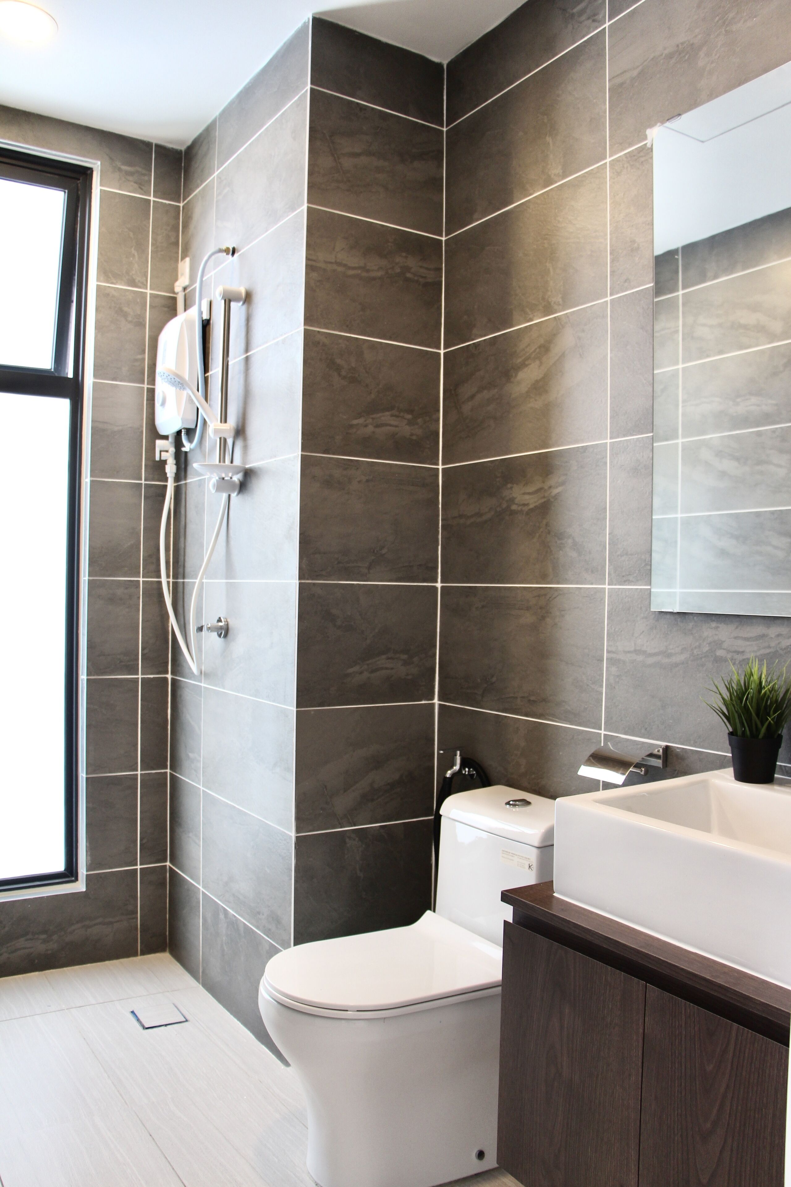 A modern bathroom with a toilet, a shower, and a sink.