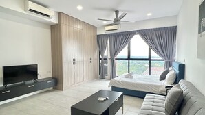 Une chambre moderne avec un lit, un canapé, une télévision et un ventilateur de plafond.