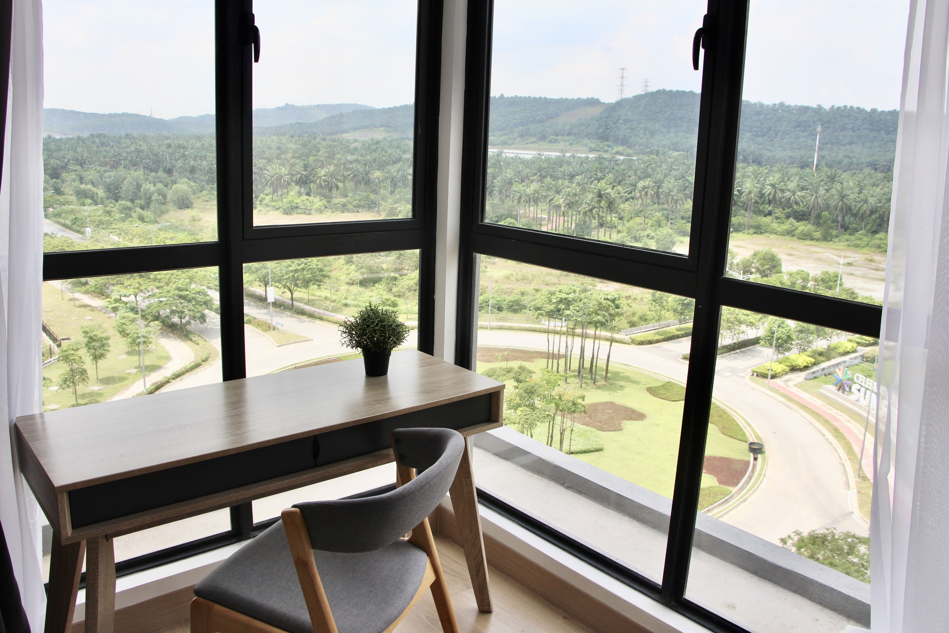 A room with a large window, a desk, and a chair.