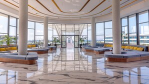 A spacious lobby with large windows, a central walkway, and seating areas with yellow cushions. - Lyttos Mare Adults Friendly 12+ (Hersonissos)