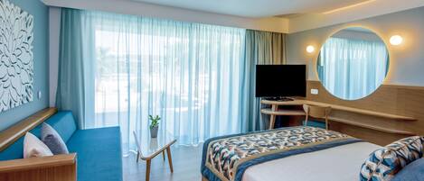 A modern hotel room with a bed, a desk, a TV, and a large window with curtains.