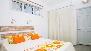 Una camera da letto con un letto, due luci a parete, una finestra vista e una porta.