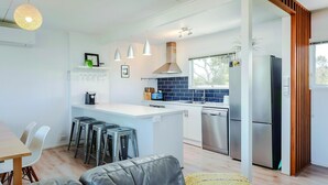 A modern kitchen with a central island, stainless steel appliances, and pendant lighting. - Aldinga Beach Breakaway - Coastal Beauty Perfect For a Fam Vacay ~ C21 (Aldinga Beach)