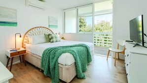 A bedroom with a bed, bedside table, lamp, and a TV. - Aldinga Beach Breakaway - Coastal Beauty Perfect For a Fam Vacay ~ C21 (Aldinga Beach)