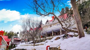 A snow-covered building with a red roof, stone walls, and a staircase leading up to the entrance. - Regenta Resort & Spa Mashobra (Shimla)