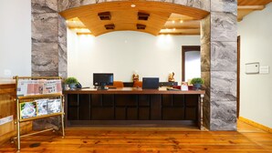 A reception desk with a marble wall backdrop, wooden ceiling, and a bulletin board with magazines. - Regenta Resort & Spa Mashobra (Shimla)