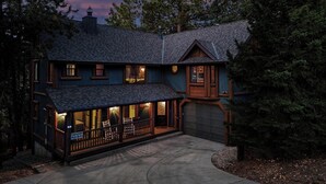 Ein zweistöckiges Haus mit Veranda, Garage und Schornstein.