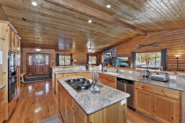 Una cocina amplia con armarios de madera, encimeras de granito y electrodomésticos modernos.