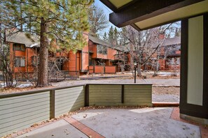 A building with multiple windows and balconies, surrounded by trees and a paved area.