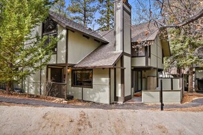 A two-story house with a chimney, a porch, and a garage.