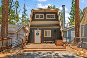 A two-story cabin with a front porch, a chimney, and a fenced yard. - Lower Moonridge! Close to Zoo, Bear Mountain Resort, Golf Course & Hiking/Biking Trails! Fenced Yard! (Big Bear Lake CA)
