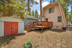 A two-story house with a wooden deck and a garage.