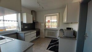 Una cocina con estufa, horno y ventana.