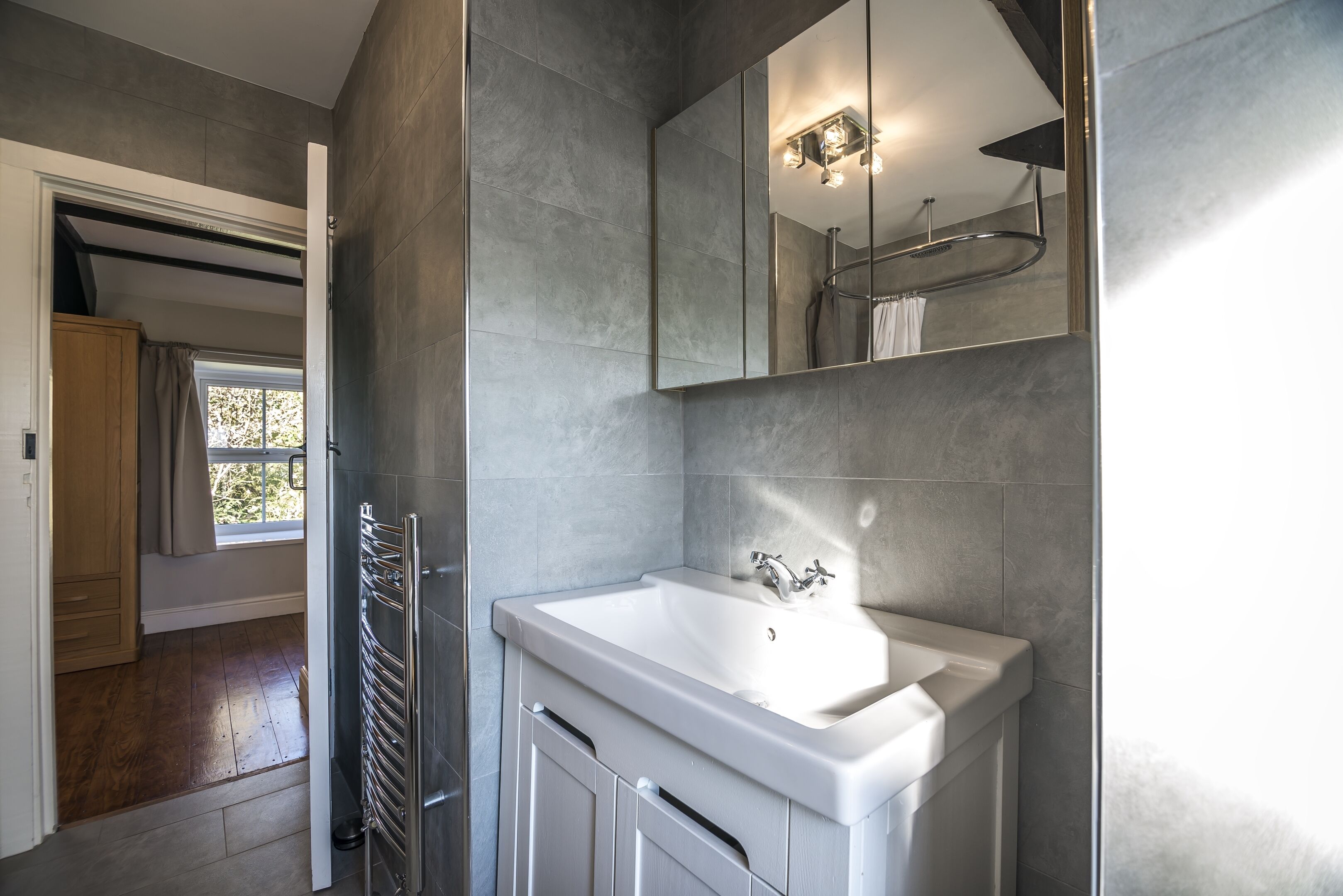 Un baño moderno con un lavamanos grande, un espejo y una ducha.