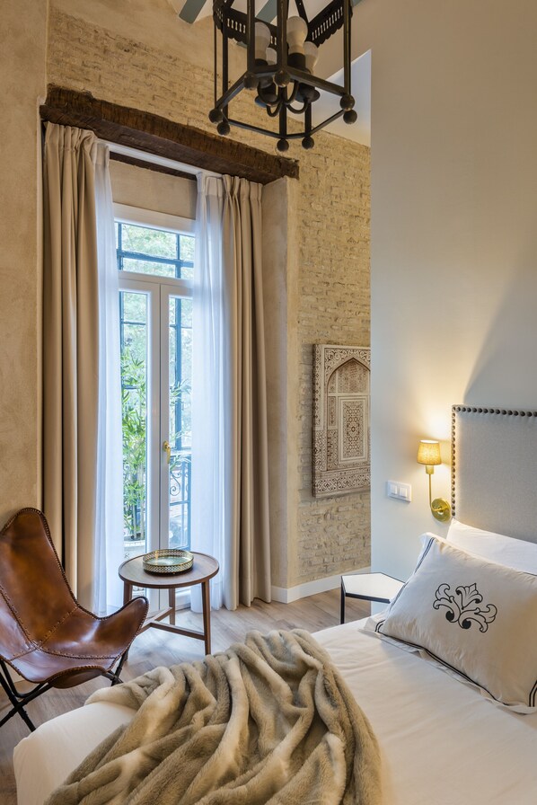 Relax in a cozy retreat with a plush bed, comfortable armchair, and warm ambiance.
