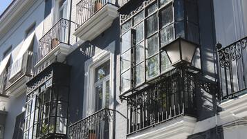 A multi-story building with white-framed windows and black wrought iron balconies.