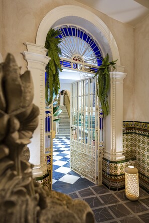 A grand hallway with a checkered floor, a blue and white arched ceiling, and a staircase leading upwards. - Casa Sevilla 1855 Suites by Época (Seville)