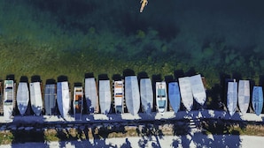 Vários barcos alinhados à beira da água.