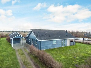 A two-story house with a sloped roof, a garage, and a small porch. - 5 Star Holiday Home in Tarm (Tarm)
