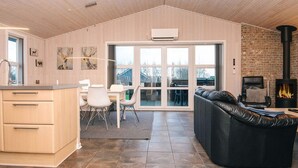 Eine moderne Küche mit Essbereich, Kamin und großem Fenster.