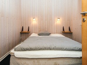 A bedroom with a bed, two wall-mounted shelves, and two wall lights. - 5 Star Holiday Home in Tarm (Tarm)