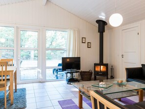 A living room with a fireplace, a television, and a glass coffee table. - 4 Star Holiday Home in Henne (Henne)