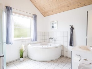 Un baño moderno con una bañera independiente, un inodoro y un lavabo.