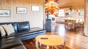 A modern living room with a leather sofa, a round coffee table, and a unique ceiling light fixture. - 4 Star Holiday Home in Tarm (Tarm)