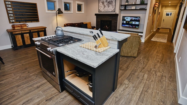 Een moderne keuken met een ingebouwde kookplaat, een marmeren aanrecht en een houten kast.
