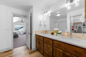 A modern bathroom with a large mirror, wooden cabinets, and a white countertop. - The Highland Hangout: Luxurious, new 3 bed, 3 bath townhome in McCall with garage (McCall)