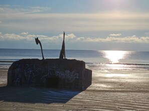 A concrete structure with graffiti on a beach with the ocean in the background. - 5 Star Holiday Home in Blavand (Blavand)