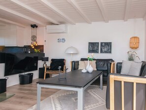 A modern living space with a kitchen, dining area, and seating area.