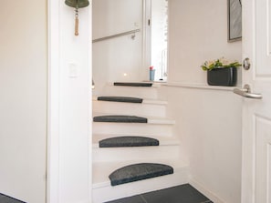 A staircase with white walls and dark steps leading to a door. - 5 Star Holiday Home in Fano (Fano)