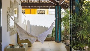 A hammock hanging between two walls, a tiled floor, and potted plants. - GB19 Casa 7 Quartos a 50m da Praia (Camaçari)