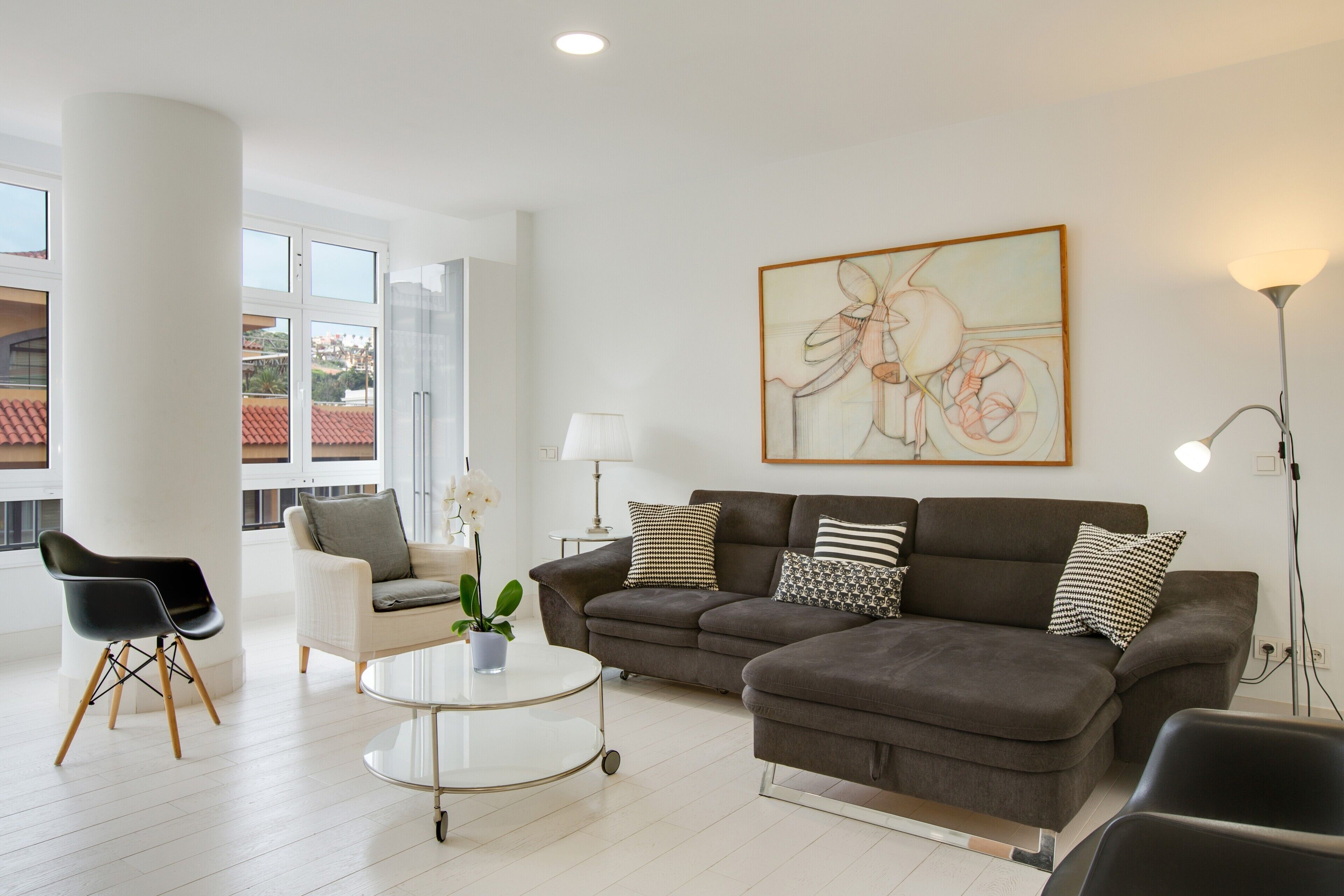 A modern living room with a sofa, armchairs, a coffee table, and a lamp.